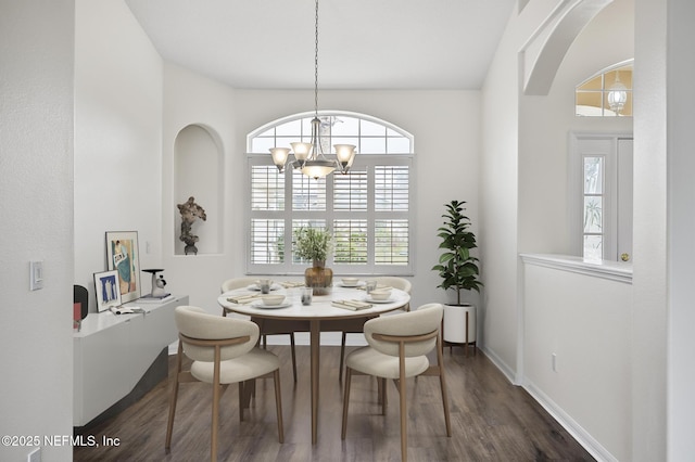 dining space featuring an inviting chandelier, plenty of natural light, and dark hardwood / wood-style floors