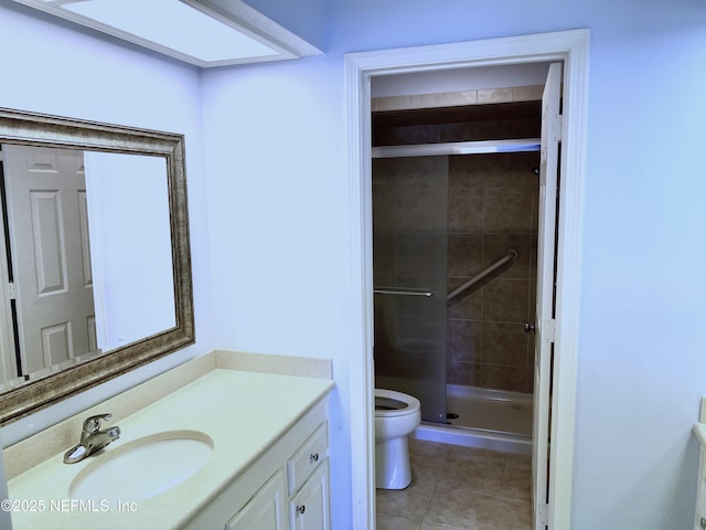 bathroom with vanity, a shower with shower door, tile patterned floors, and toilet