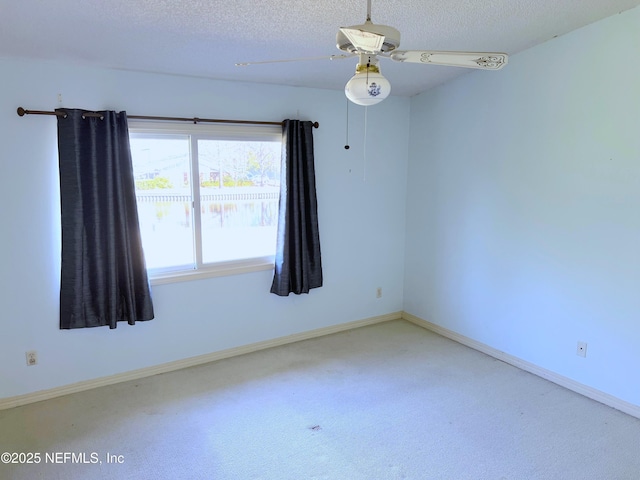 carpeted spare room with ceiling fan and a textured ceiling