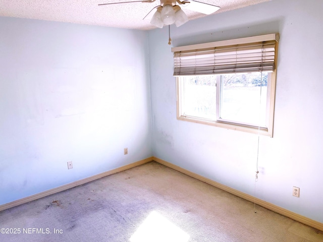 carpeted spare room with ceiling fan and a textured ceiling