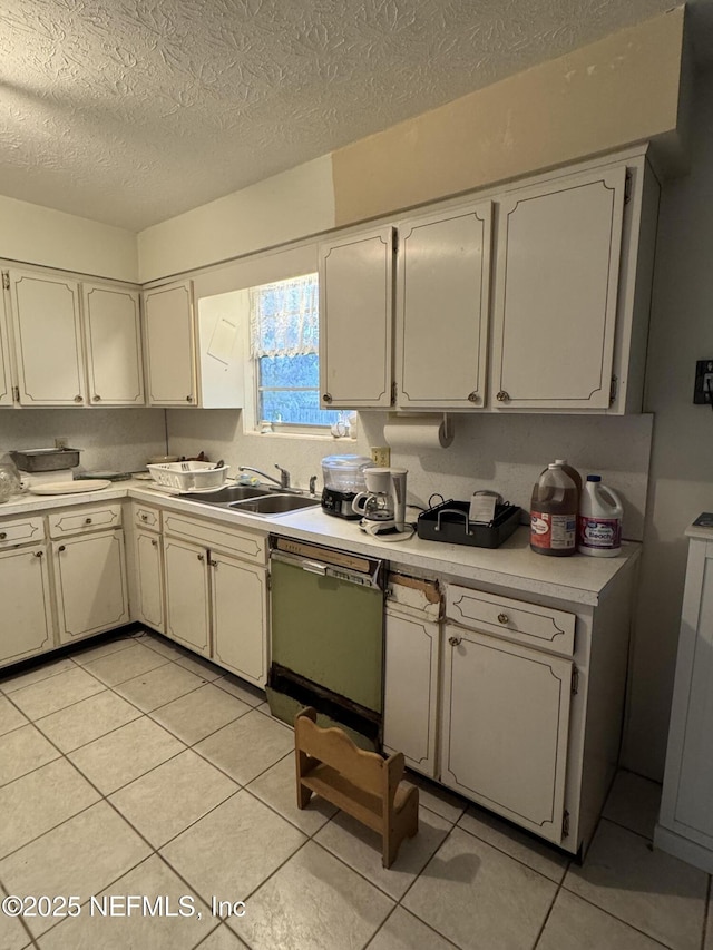 kitchen with stainless steel dishwasher, sink, a textured ceiling, and light tile patterned floors