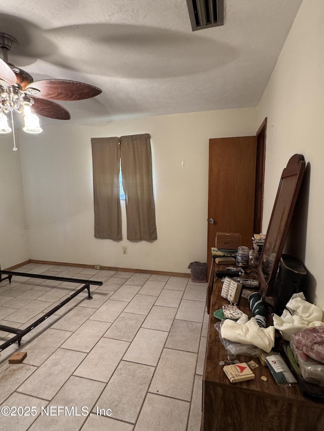 bedroom with light tile patterned flooring and a textured ceiling