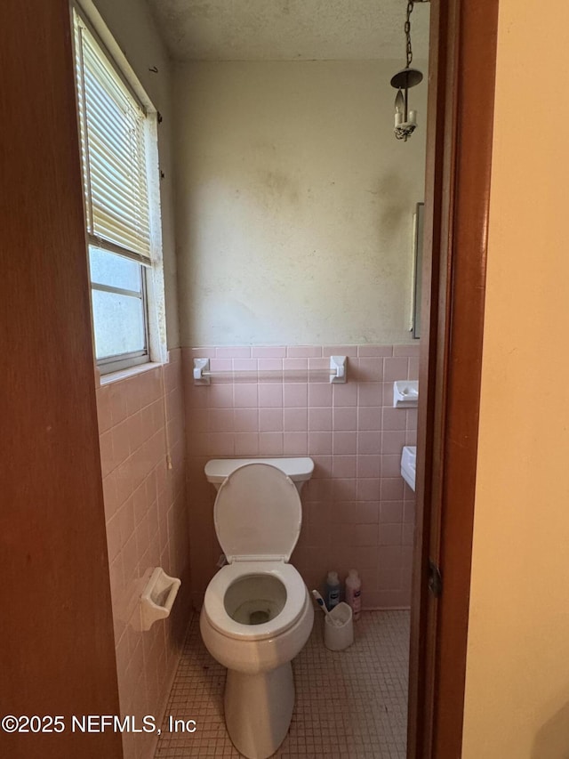 bathroom featuring tile walls, a wealth of natural light, and tile patterned floors