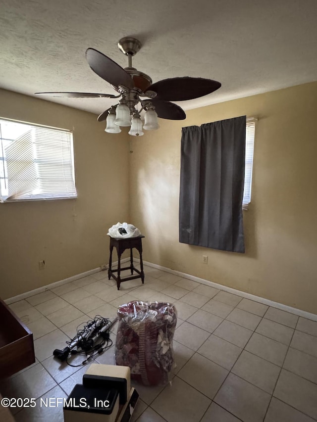 tiled spare room featuring a wealth of natural light and ceiling fan