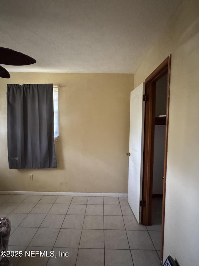 empty room featuring light tile patterned floors and ceiling fan