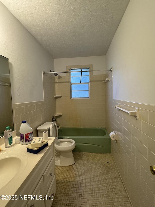 full bathroom featuring tiled shower / bath combo, tile patterned floors, a textured ceiling, and toilet