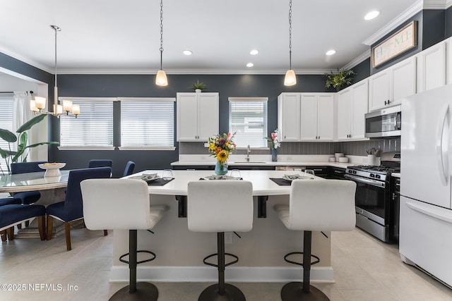 kitchen with stainless steel appliances, a kitchen bar, and hanging light fixtures