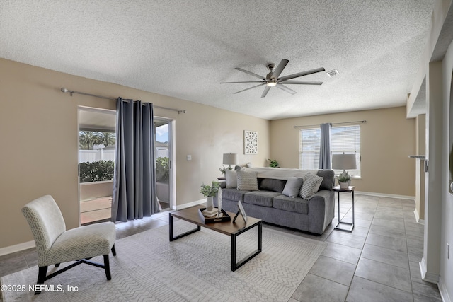 living room with light tile patterned floors, a textured ceiling, and ceiling fan