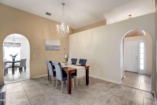 dining area featuring light tile patterned floors, vaulted ceiling, and a notable chandelier