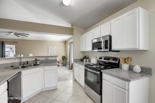 kitchen with light tile patterned flooring, white cabinetry, sink, stainless steel appliances, and a textured ceiling