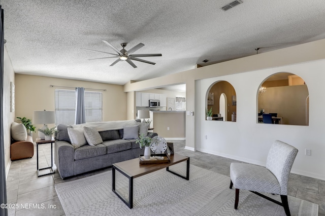 living room featuring ceiling fan and a textured ceiling