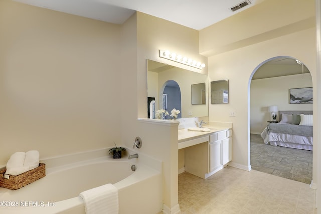 bathroom featuring a washtub and vanity