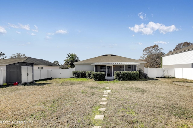 back of property with a storage shed, a sunroom, and a lawn