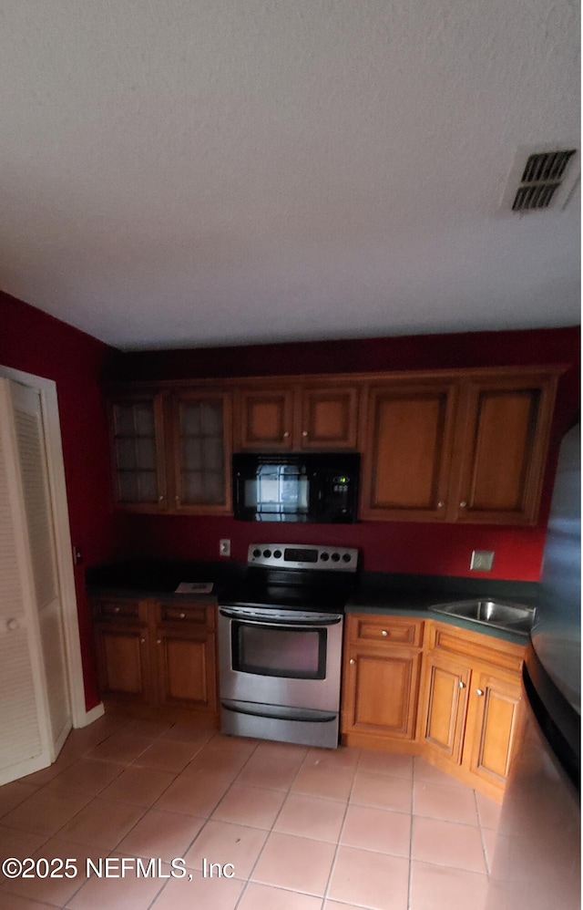 kitchen featuring light tile patterned flooring, stainless steel appliances, and sink