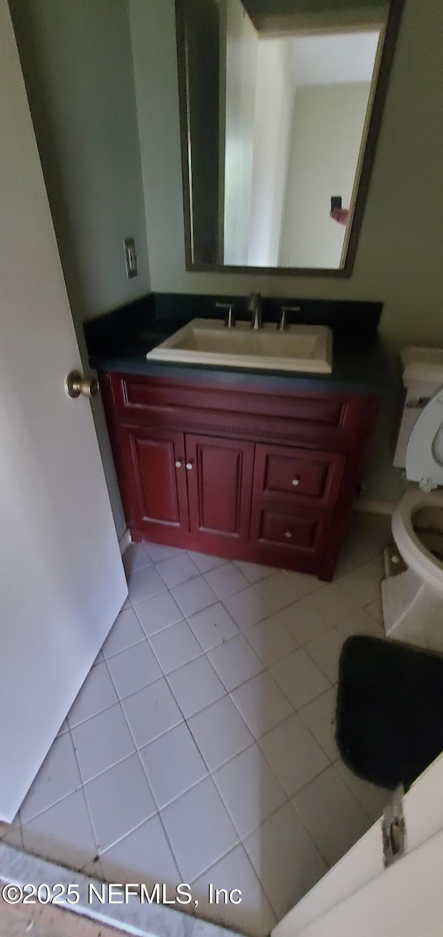 bathroom featuring tile patterned flooring, vanity, and toilet