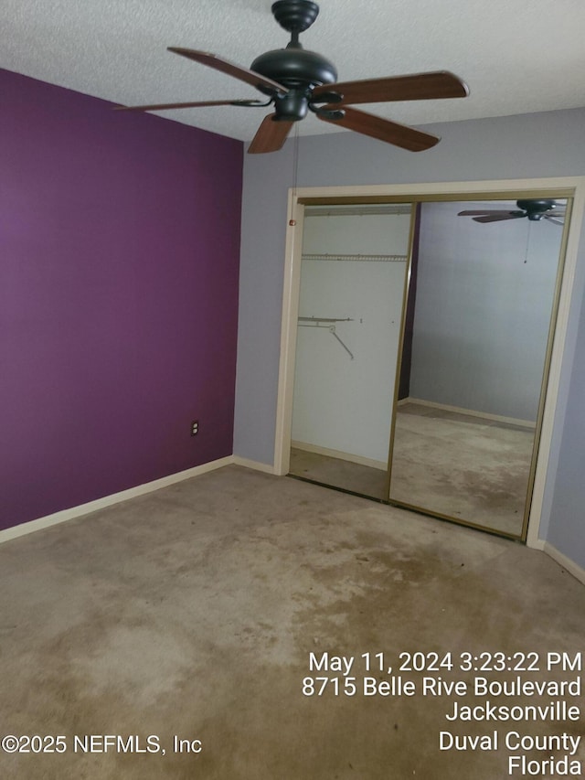 unfurnished bedroom featuring ceiling fan, carpet flooring, a closet, and a textured ceiling