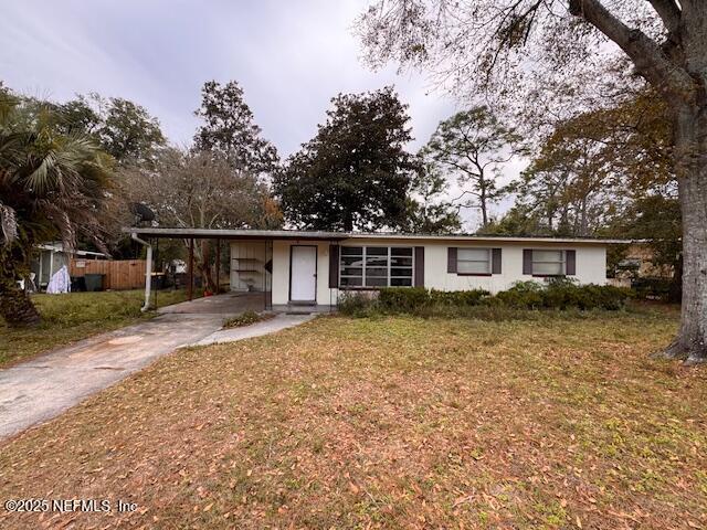 ranch-style home with a carport and a front lawn