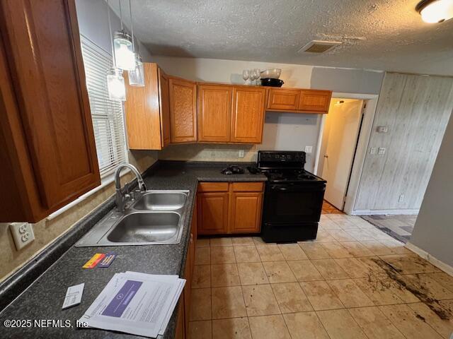 kitchen with black range oven, sink, hanging light fixtures, and a textured ceiling