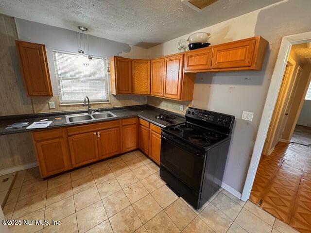 kitchen featuring decorative light fixtures, black electric range oven, sink, and a textured ceiling