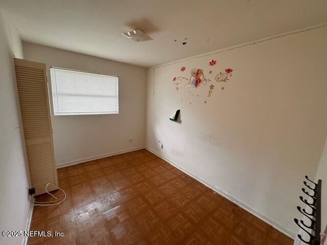 unfurnished room featuring parquet flooring