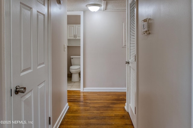 hallway with dark wood-type flooring and a textured ceiling