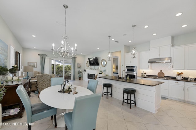 tiled dining space with an inviting chandelier and a fireplace