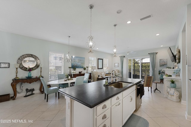 kitchen featuring light tile patterned flooring, sink, dishwasher, a kitchen island with sink, and white cabinets