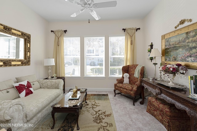 living area with ceiling fan and light carpet