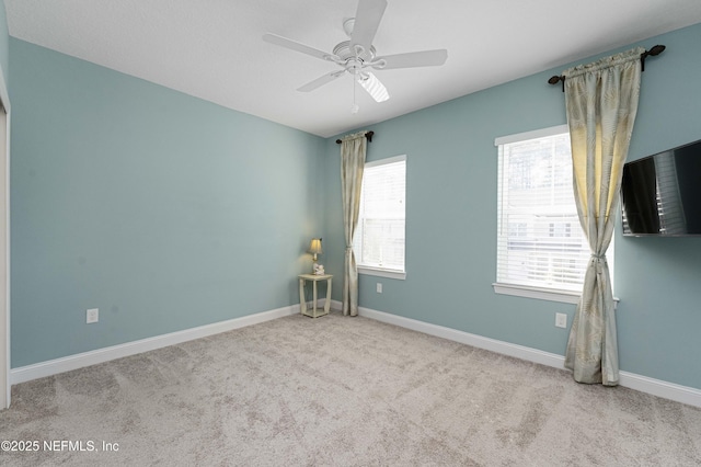 empty room featuring light colored carpet and ceiling fan