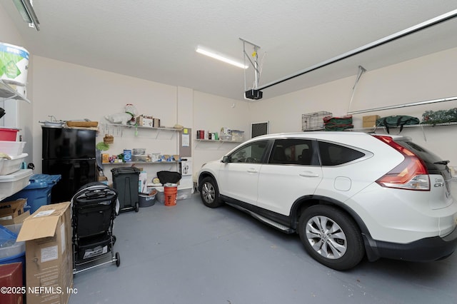 garage featuring black refrigerator and a garage door opener