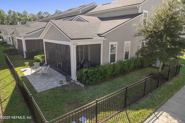 view of property exterior featuring a patio, a sunroom, and a lawn