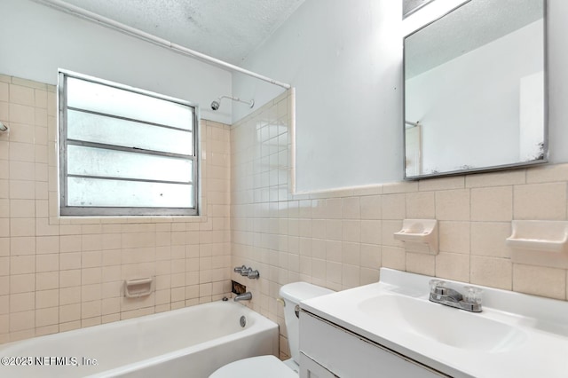 full bathroom with tile walls, vanity, a wealth of natural light, and a textured ceiling