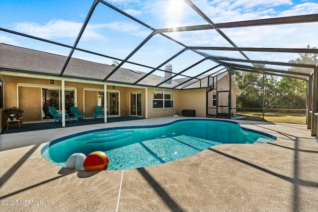 view of pool with a patio and glass enclosure