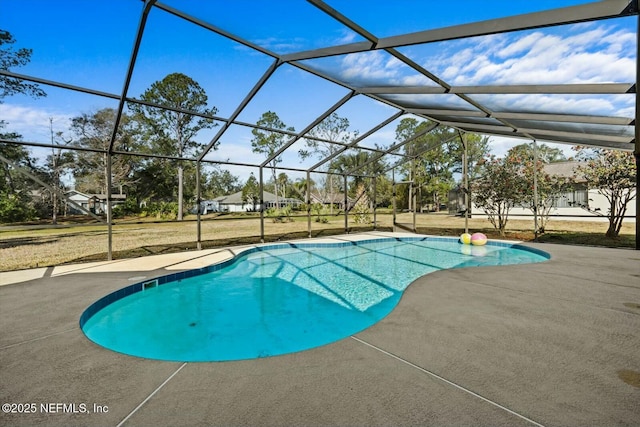 view of pool with a yard, a patio, and glass enclosure