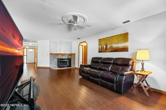 living room featuring hardwood / wood-style floors, a textured ceiling, and ceiling fan