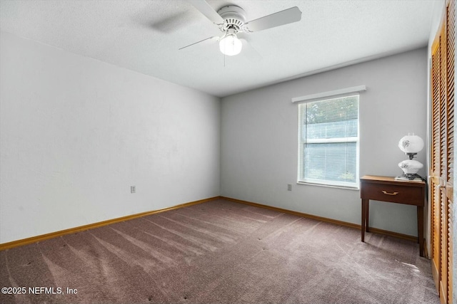 carpeted empty room with ceiling fan and a textured ceiling