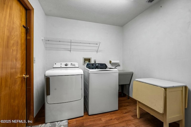 laundry room featuring hardwood / wood-style flooring, independent washer and dryer, and a textured ceiling