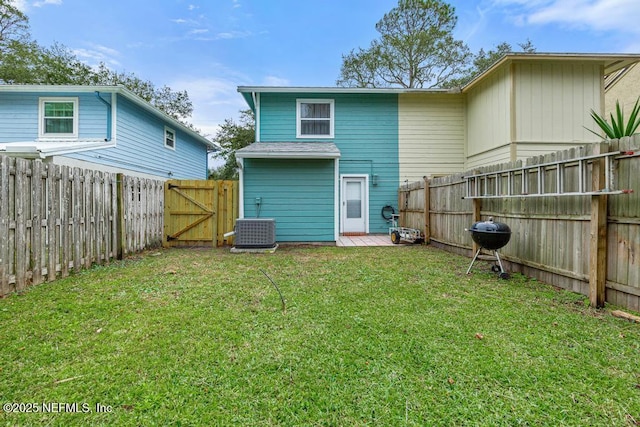 back of property with a yard and central air condition unit