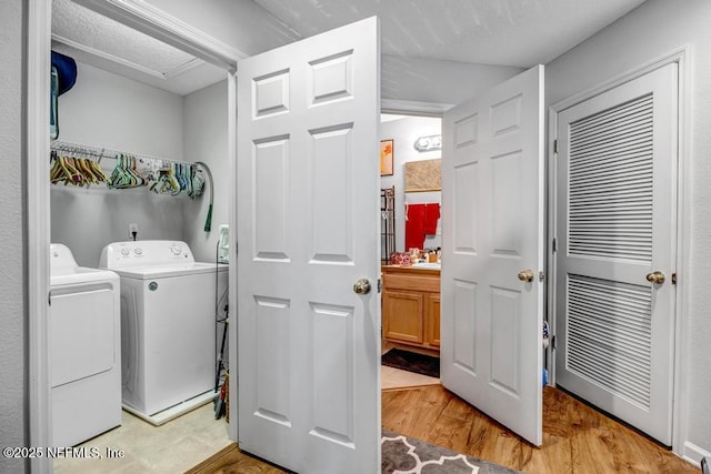 washroom with separate washer and dryer and light hardwood / wood-style floors