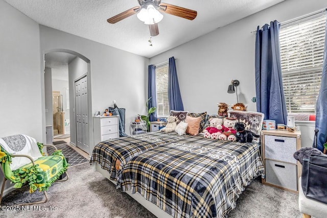 carpeted bedroom with connected bathroom, a textured ceiling, and ceiling fan