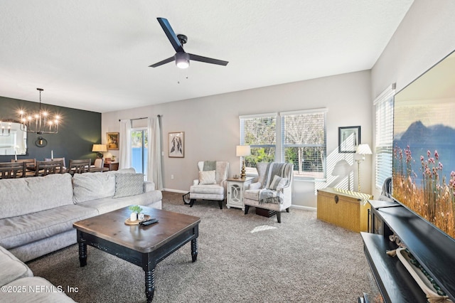 living room with ceiling fan with notable chandelier, a textured ceiling, and carpet