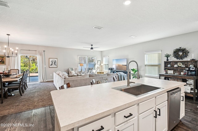 kitchen featuring sink, stainless steel dishwasher, pendant lighting, a kitchen island with sink, and white cabinets