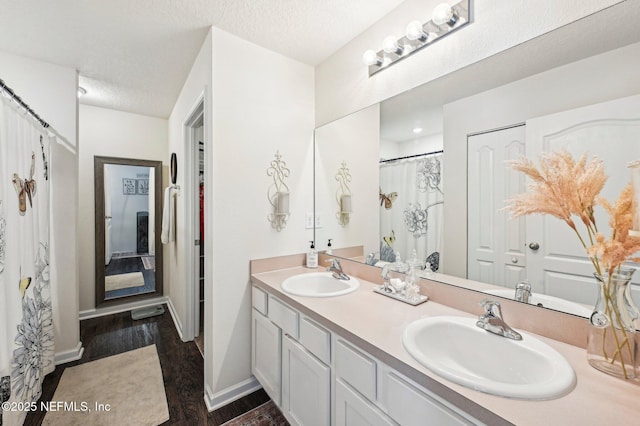 bathroom featuring vanity, hardwood / wood-style flooring, and a textured ceiling