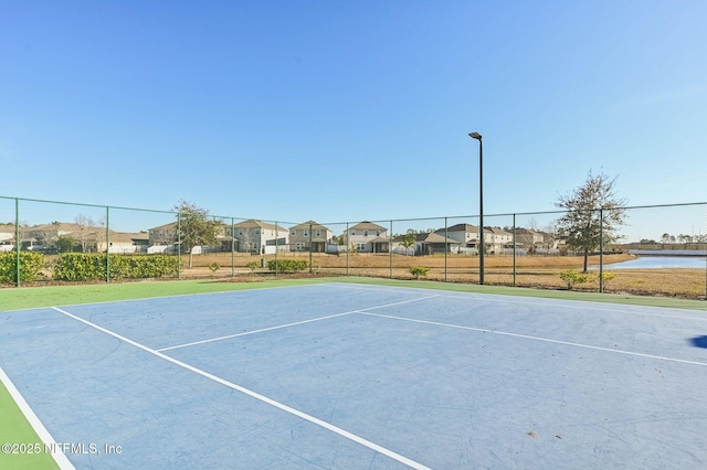 view of sport court with a water view