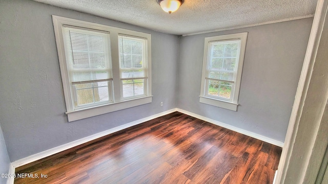 empty room with dark hardwood / wood-style flooring and a textured ceiling