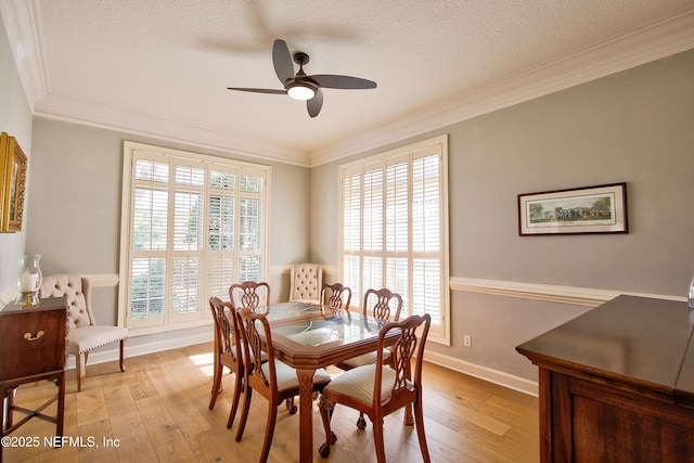 dining area featuring a healthy amount of sunlight, light hardwood / wood-style flooring, and a textured ceiling