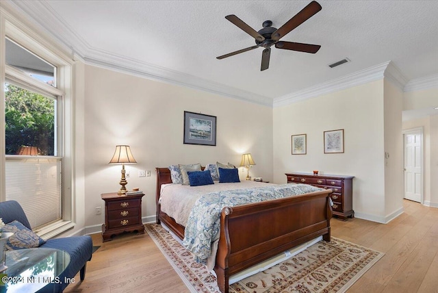 bedroom featuring a textured ceiling, ornamental molding, light hardwood / wood-style floors, and ceiling fan