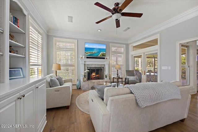 living room with ornamental molding, hardwood / wood-style floors, a textured ceiling, and a wealth of natural light