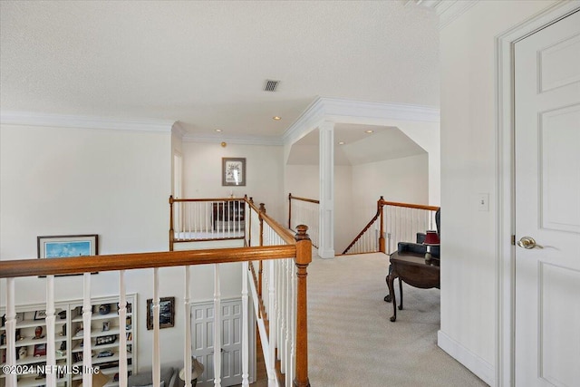 hall with crown molding, carpet flooring, and a textured ceiling