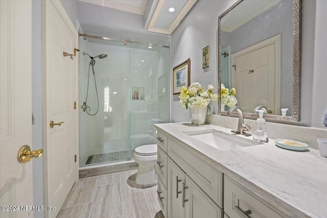 bathroom with vanity, crown molding, a shower with shower door, and toilet